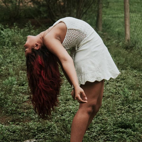 Woman stretching gracefully outdoors, showing flexibility and energy.